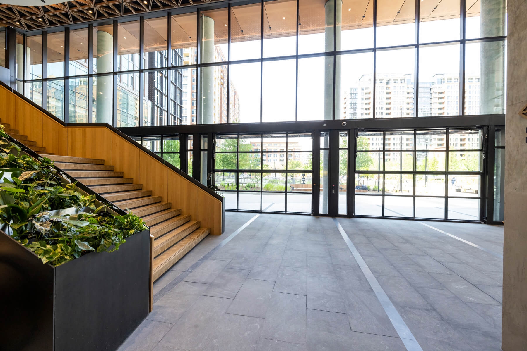 An image of a large staircase in the lobby of Amazon's second headquarters. There is a large window wall in the background 