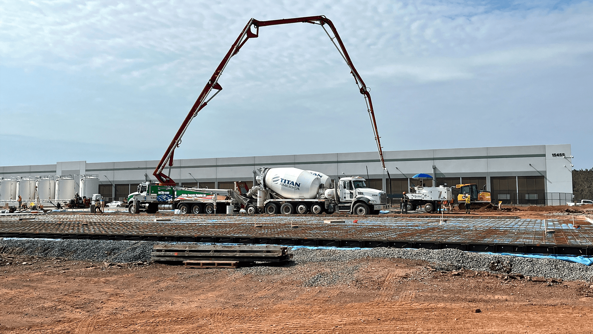 A photo of cement trucks pouring concrete outside of an AWS data center that is under construction.