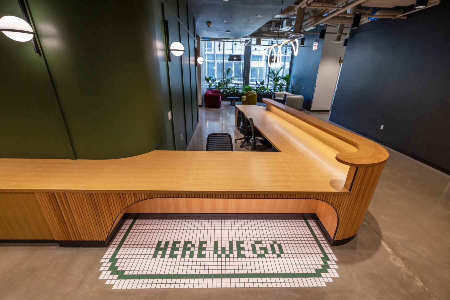 The coffee bar at Amazon HQ2. There is tiling that says "here we go."