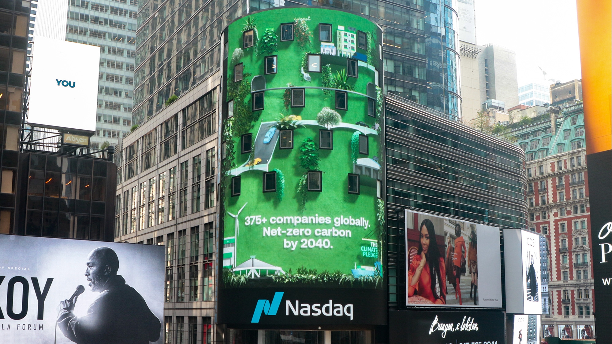 An image of a Climate Pledge Nasdaq Sign on a building that reads "375+ companies globally. Net-zero carbon by 2040."