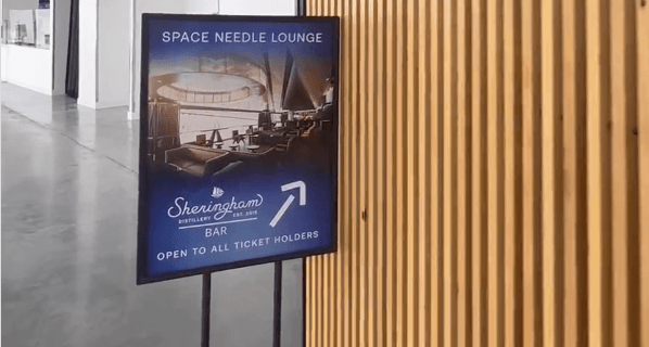 An image of a sign that points up and says "Space Needle Lounge"