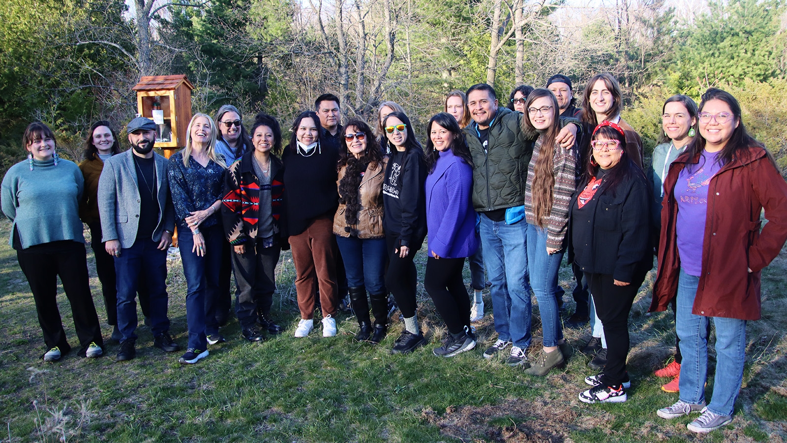 A photo of 21 members of Indigenous Nations Poets standing outside.
