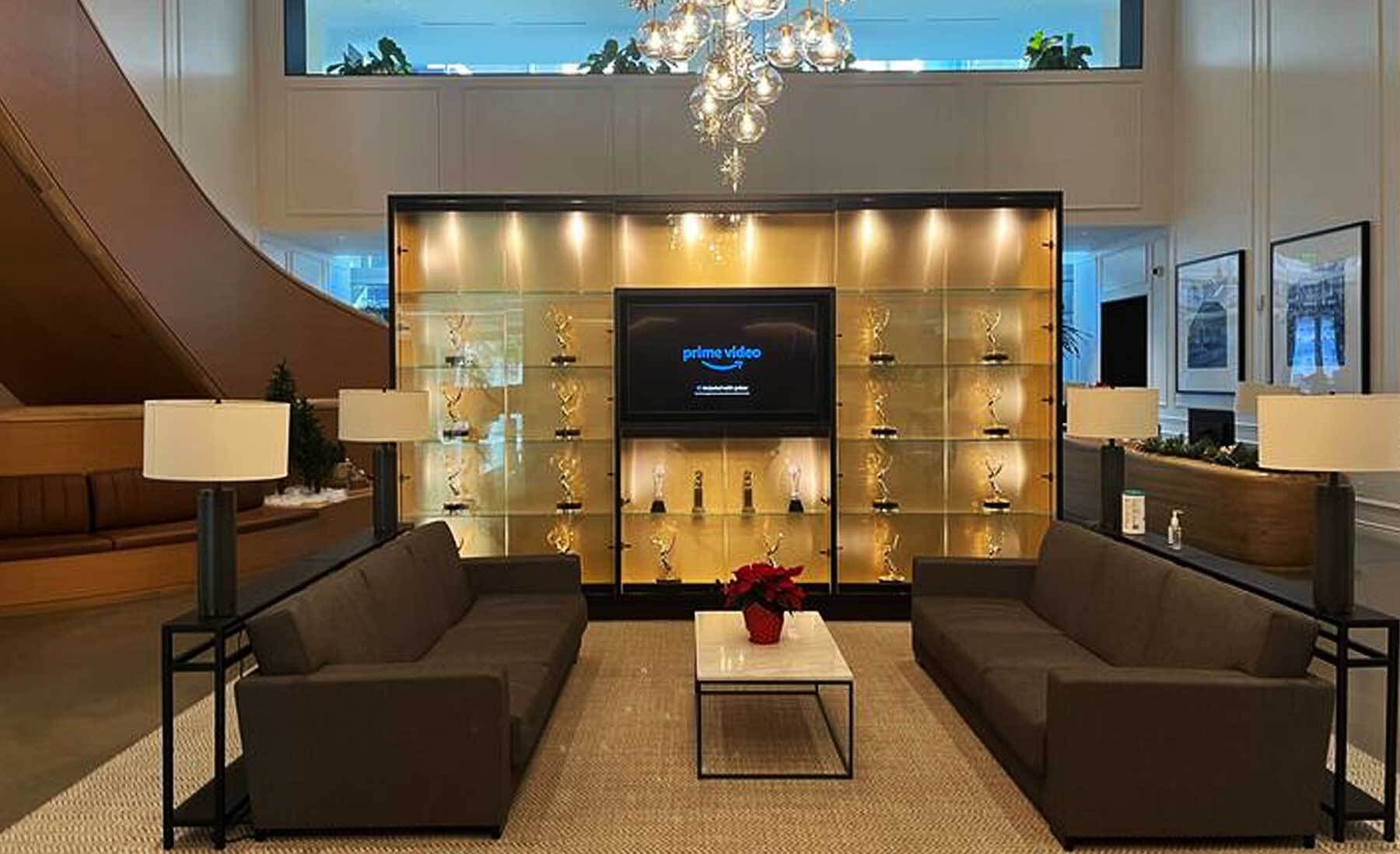 An image of a case of Emmy awards with couches around it in a lobby. There is a screen in the middle that says "Prime Video."