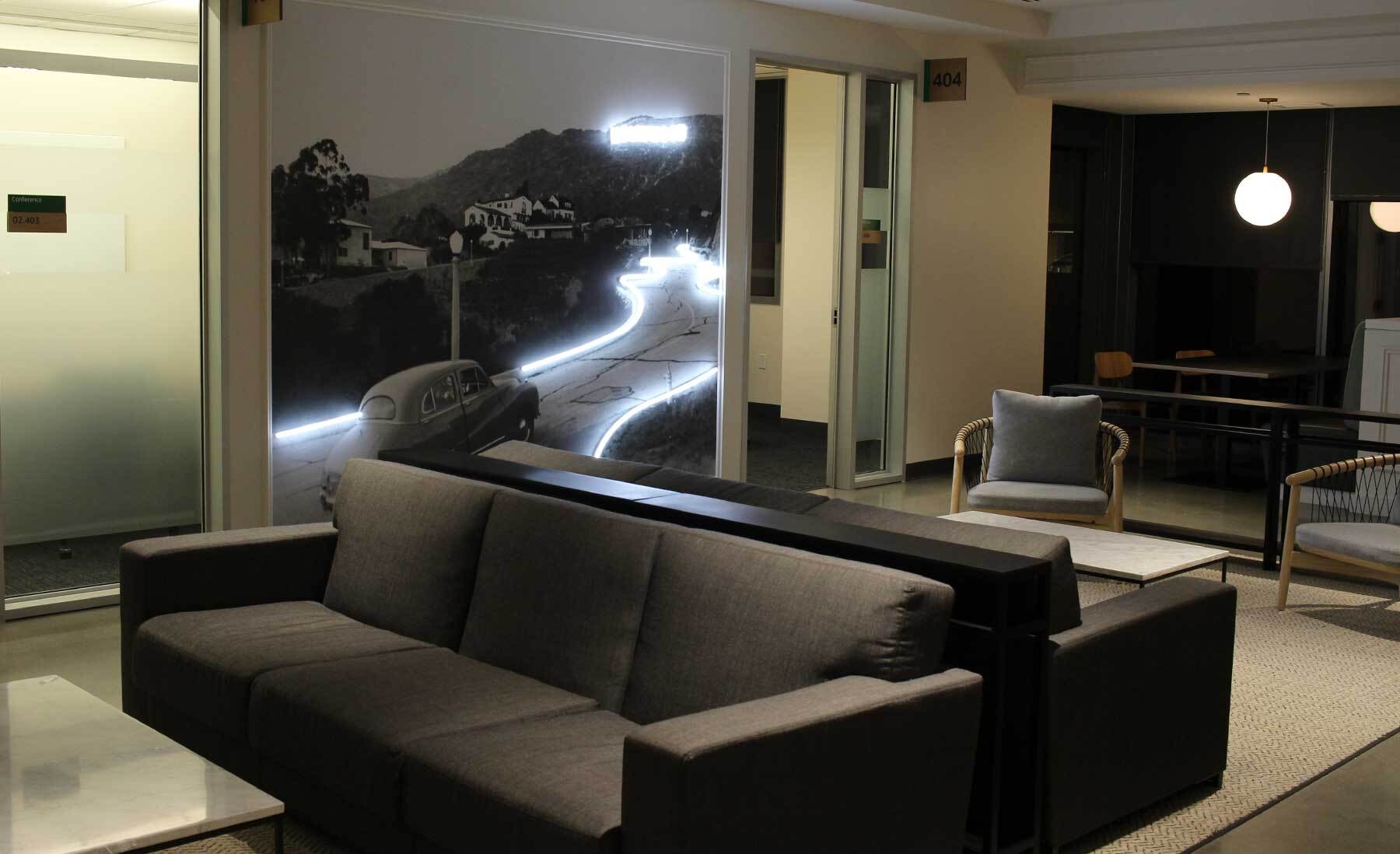 An image of a sitting area with a lit-up mural on the wall showing the hollywood sign