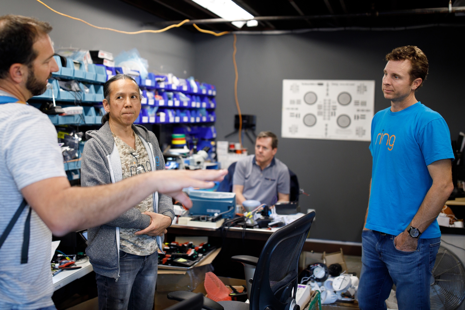 Jamie Siminoff, founder of Ring, in a blue t-shirt and jeans, talks to engineers in a lab at Ring headquarters in Santa Monica, CA. 