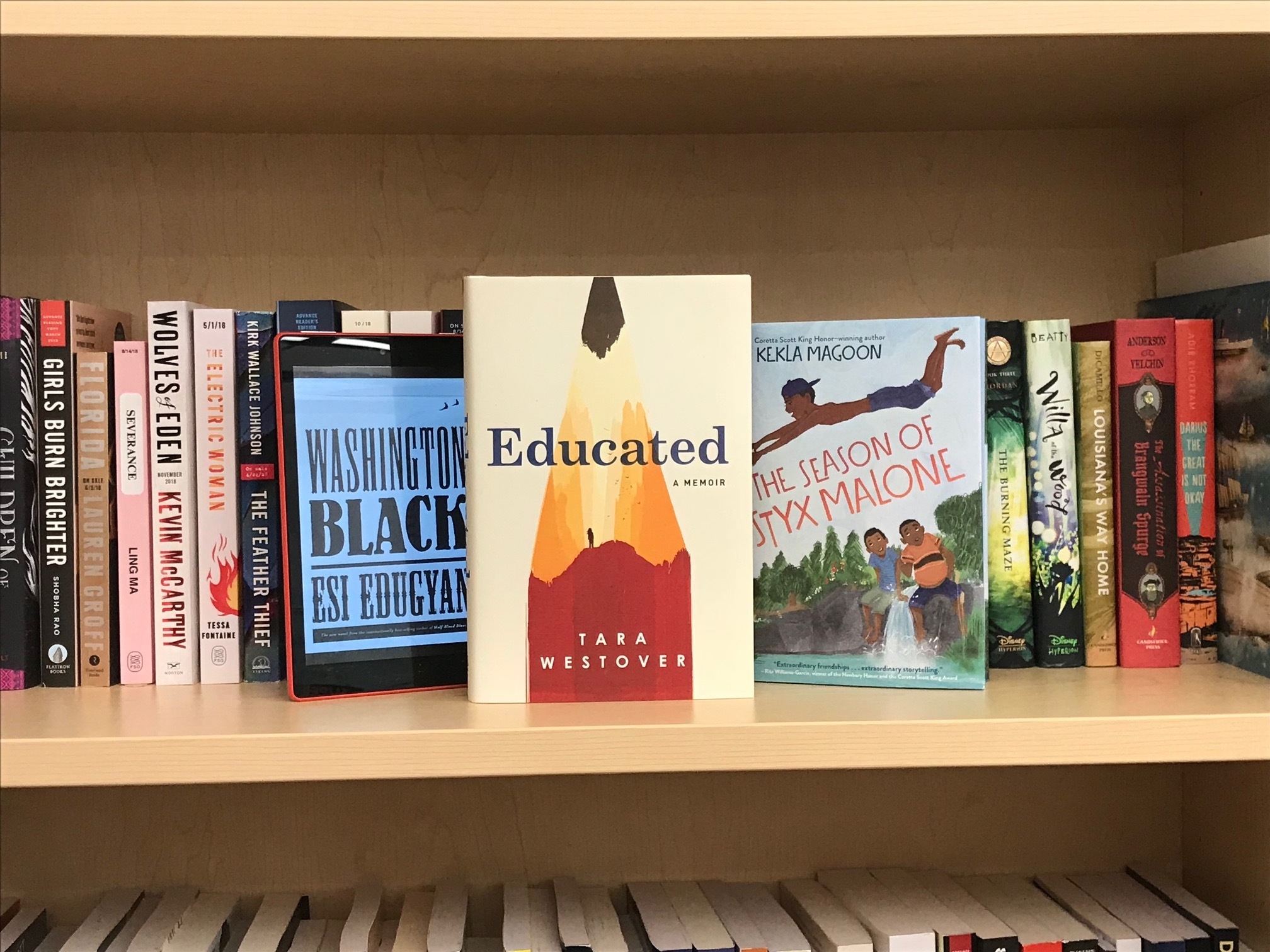 A bookshelf with dozens of books, including the best book of the year, Tara Westover's Educated: A Memoir, The Season of Styx Malone, and Washington Black.