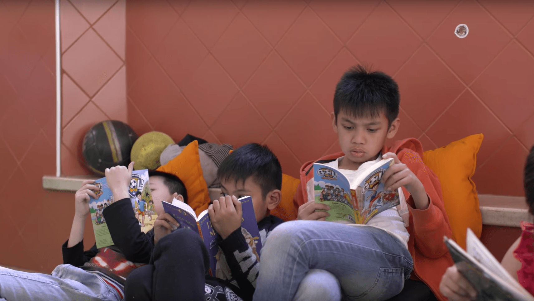 Three young boys enjoying reading their books on World Book Day