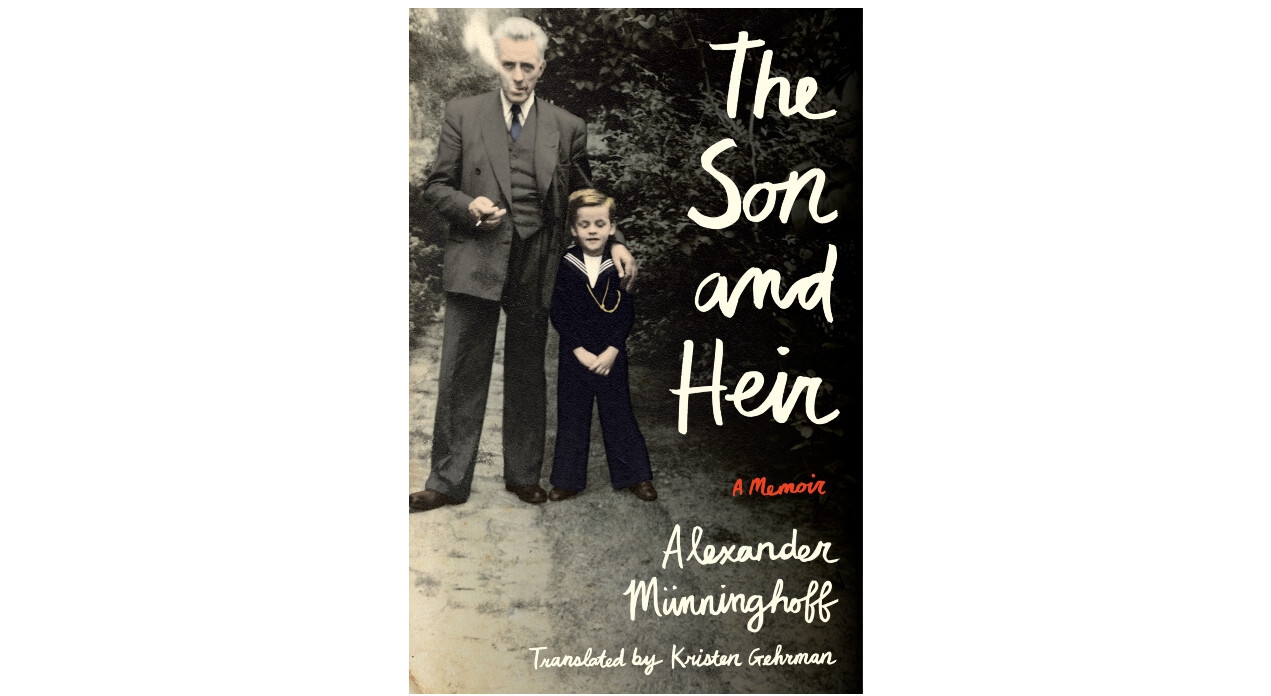 The book cover of "The Son and Heir" features a vintage image of a an older man blowing smoke out of his mouth holding a pipe in one hand and his other arm is around the arm of young boy. The older man wears a suit and the younger boy wears a sailor-like suit. They stand on a dirt path surrounded by trees.