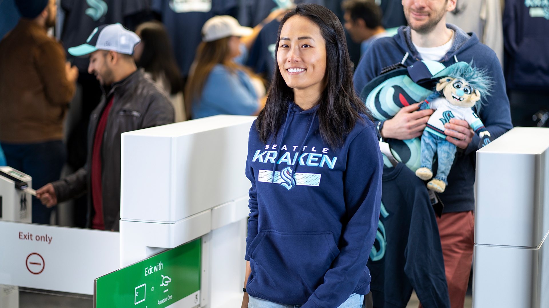 A photo of a customer walking out of a Kraken Team Store, that uses Just Walk Out technology.