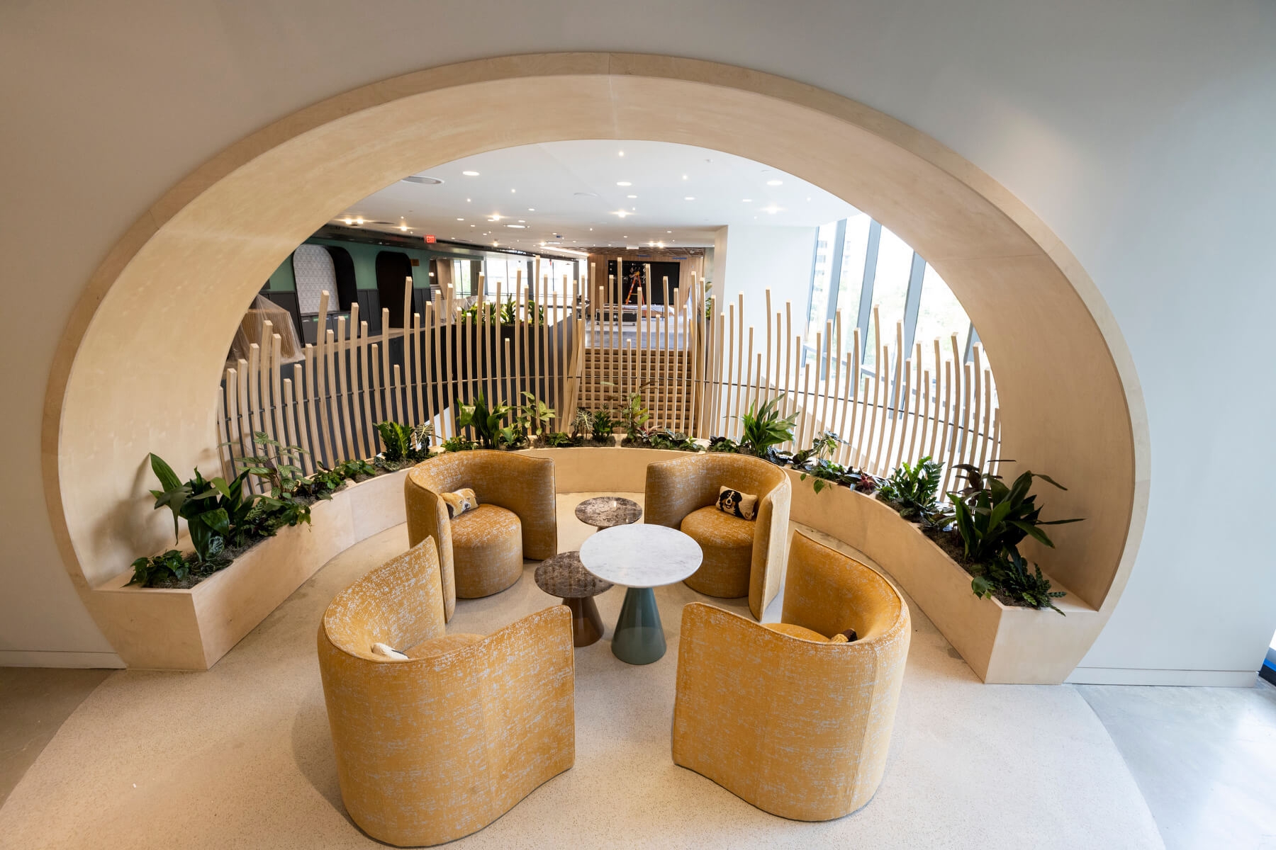 An image of a round bench seating area with plants and elaborate woodwork